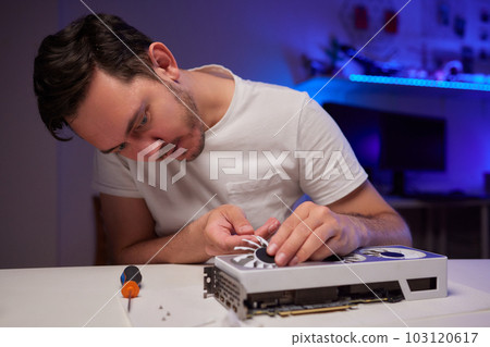 Changing the thermal paste on the graphics processor. Disassembled graphics card on the table. Old graphics card service. 103120617