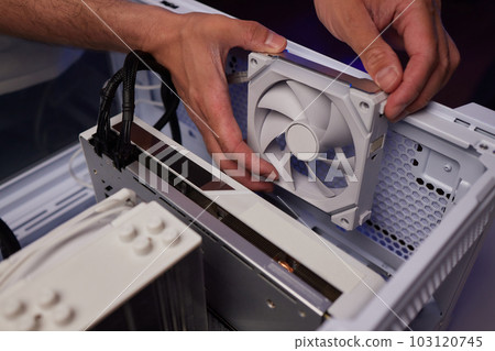 Computer technician installs cooling system of computer. Computer technician installs cooling system of computer. 103120745