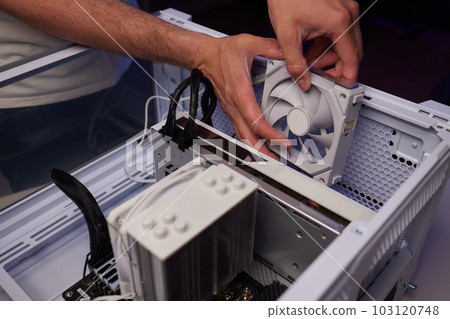 Computer technician installs cooling system of computer. Computer technician installs cooling system of computer. 103120748