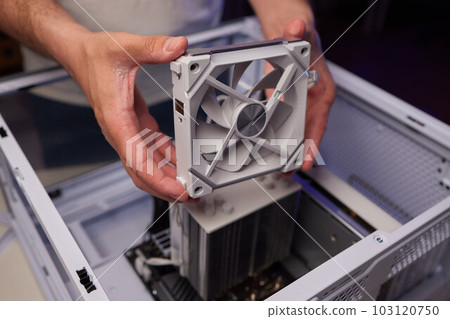 Computer technician installs cooling system of computer. Computer technician installs cooling system of computer. 103120750
