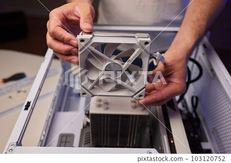Computer technician installs cooling system of computer. Computer technician installs cooling system of computer. 103120752