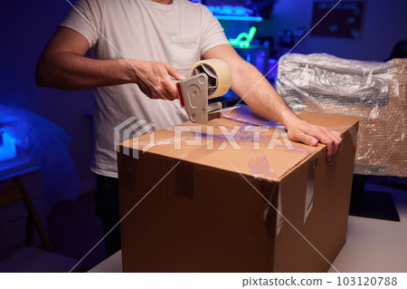 young man packing a monitor in a cardboard box. 103120788