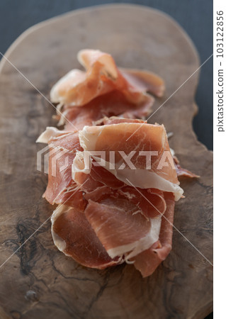 Thin slices of jamon on olive wood board Thin slices of jamon on olive wood board 103122856