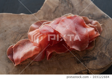 bresaola slices on olive wood board bresaola slices on olive wood board 103122884