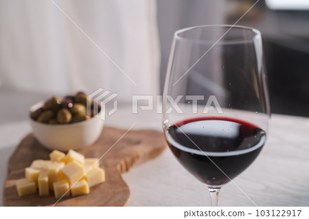 Red wine with olives and vintage cheese on white table 103122917