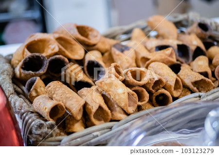 Sweet empty fried cannoli in basket on counter at food market 103123279