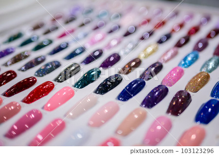 Many colorful palletes of gel nail polishes on counter of make up store 103123296