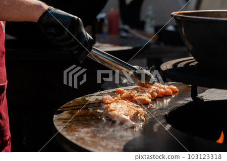 Chef cooking fried chicken meat pieces on brazier - close up 103123318