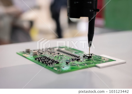 Automatic manipulator with dispenser needle during work with SMT pcb - close up 103123442
