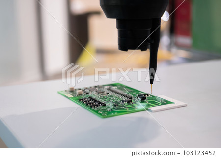 Automatic manipulator with dispenser needle during work with SMT pcb - close up 103123452