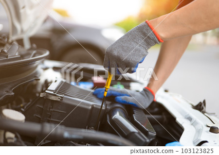 Man checking level of engine oil. Car Repairs, vehicle maintenance, car mechanic, Car inspection and maintenance concept. 103123825