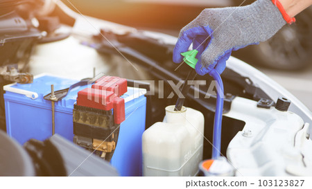 Car mechanic hand is opening the radiator cap to check the coolant level of the car radiator. Check Car radiator, car yourself, Car Repair, vehicle maintenance, Car inspection and maintenance concept. Car mechanic hand is opening the radiator cap to check the coolant level of the car radiator. Check Car radiator, car yourself, Car Repair, vehicle maintenance, Car inspection and maintenance concept. 103123827