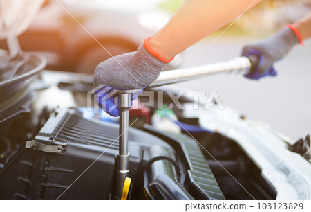 Car mechanic using the torque wrench to repairing in car engine room. a mechanics repair service garage. working on a car service. Car Maintenance and Repair concept. Car mechanic using the torque wrench to repairing in car engine room. a mechanics repair service garage. working on a car service. Car Maintenance and Repair concept. 103123829