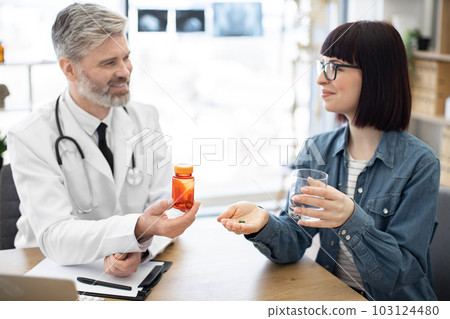 Lady receiving oral medicine from physician at hospital Lady receiving oral medicine from physician at hospital 103124480