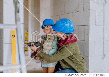 Father and his little son working on their unfinished house. Father and his little son working on their unfinished house. 103124882