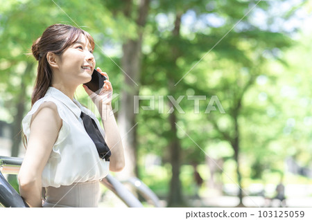 A young woman talking on a smartphone A young woman talking on a smartphone 103125059