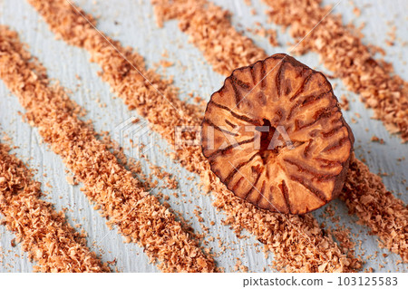 Half of nutmeg against the background of grated cocaine lanes made from grated nutmeg powder Half of nutmeg against the background of grated cocaine lanes made from grated nutmeg powder 103125583