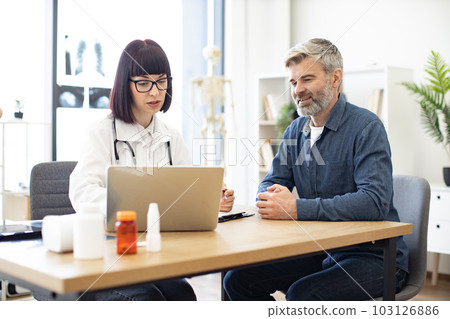 Doctor and patient discussing symptoms of illness in clinic Doctor and patient discussing symptoms of illness in clinic 103126886