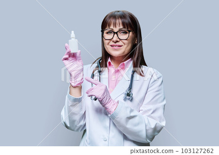 Female doctor with medicine drops for nose eyes ears, on grey background 103127262