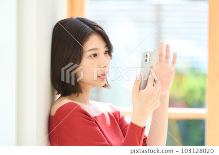 便衣的年輕女人，客廳，智能手機 103128020