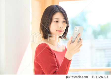 便衣的年輕女人，客廳，智能手機 103128021