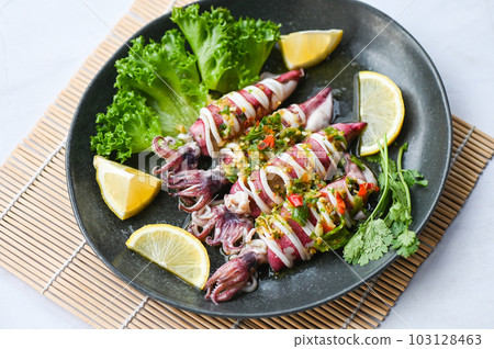 Steamed squid with lemon spicy chili and lemon sauce squid steamed with lime, Thai food seafood plate with herb and spices - top view 103128463