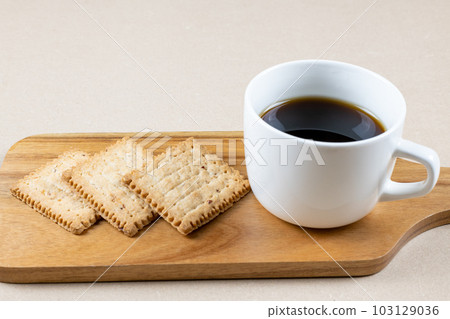 Coffee and biscuits on a wooden plate 103129036