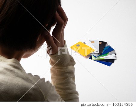 一個女人抱著頭盯著大量信用卡的背影 一個女人抱著頭盯著大量信用卡的背影 103134596