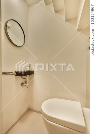 a white bathroom with a toilet and mirror on the wall next to it is a black sink in the corner a white bathroom with a toilet and mirror on the wall next to it is a black sink in the corner 103134967