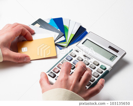 Hand of a woman holding a credit card and calculating with a calculator 103135650