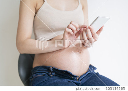 Pregnant woman using smartphone Pregnant woman using smartphone 103136265