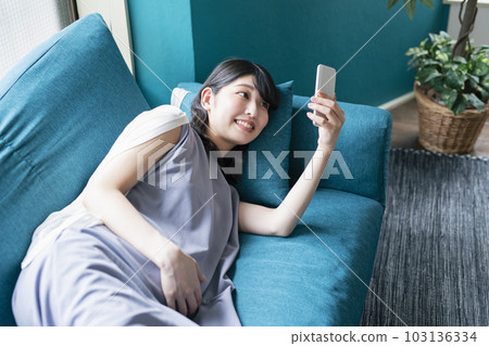 pregnant woman looking at smartphone pregnant woman looking at smartphone 103136334