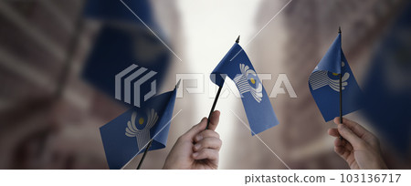 A group of people holding small flags of the CIS in their hands A group of people holding small flags of the CIS in their hands 103136717