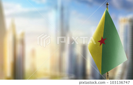 Small flags of the French Guiana on an abstract blurry background 103136747