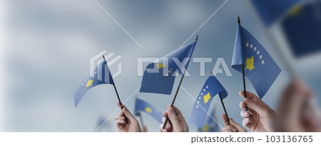 A group of people holding small flags of the Kosovo in their hands A group of people holding small flags of the Kosovo in their hands 103136765