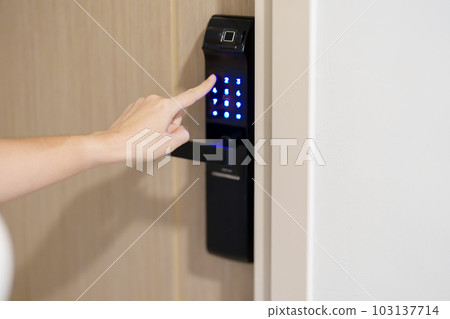Hand press PIN number for smart digital door lock while open or close the door at home or apartment. NFC Technology, Fingerprint scan, keycard, smartphone and contactless lifestyle concepts 103137714