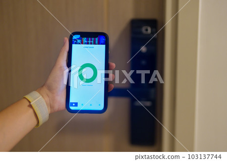 Hand using smartphone for open digital door lock at home or apartment. NFC Technology, Fingerprint scan, keycard, PIN number, smartphone, electrical and contactless lifestyle concepts 103137744