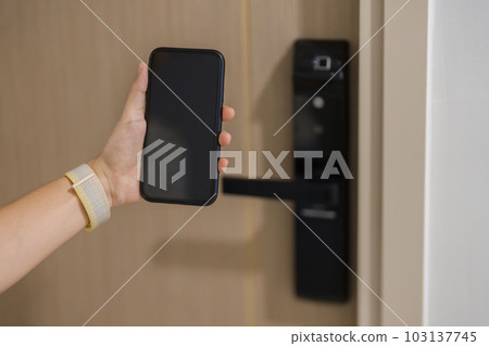 Hand using smartphone for open digital door lock at home or apartment. NFC Technology, Fingerprint scan, keycard, PIN number, smartphone, electrical and contactless lifestyle concepts Hand using smartphone for open digital door lock at home or apartment. NFC Technology, Fingerprint scan, keycard, PIN number, smartphone, electrical and contactless lifestyle concepts 103137745