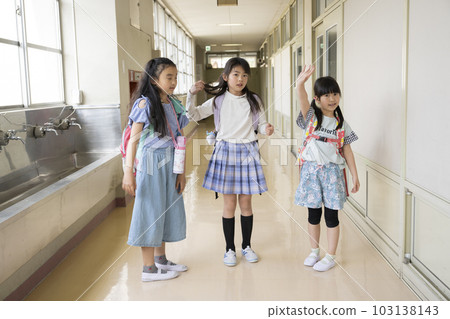 Girl waving in school corridor 103138143