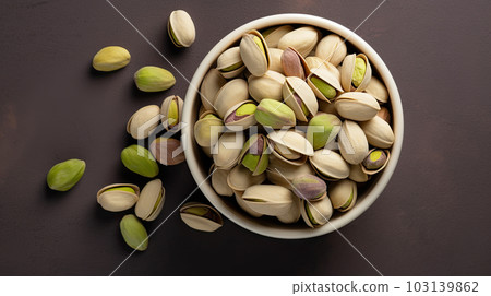 Bowl with pistachios on a wooden table. 103139862