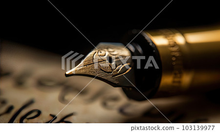 Golden fountain pen leaves drawing a straight ink line on a white paper closeup. 103139977
