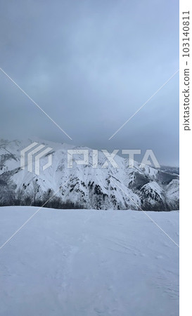 Snowy mountains visible from the ski resort on a cloudy day Snowy mountains visible from the ski resort on a cloudy day 103140811