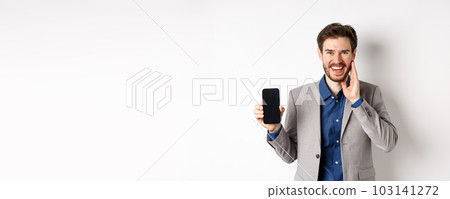 E-commerce and online shopping concept. Happy bearded guy in suit showing empty smartphone screen and laughing, standing on white background 103141272