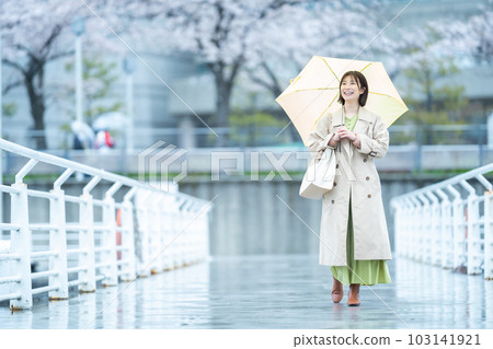 一個在雨中等待的女人 一個拿著雨傘的年輕女人 一個在雨中等待的女人 一個拿著雨傘的年輕女人 103141921