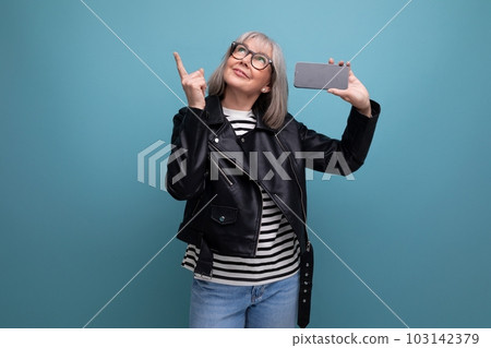 dreamy modern 60s modern old lady with gray hair holding a device vertically with a mockup on a dreamy modern 60s modern old lady with gray hair holding a device vertically with a mockup on a 103142379