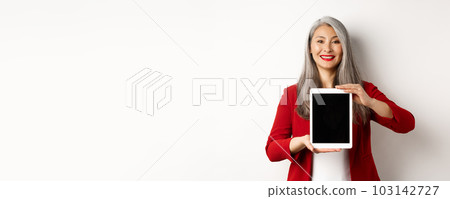 Business. Proud asian female manager showing blank digital tablet screen, smiling and demonstrating promo, standing over white background Business. Proud asian female manager showing blank digital tablet screen, smiling and demonstrating promo, standing over white background 103142727