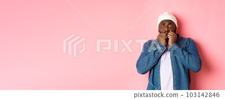 Scared Black guy trembling from fear, biting fingernails and staring at camera, standing over pink background Scared Black guy trembling from fear, biting fingernails and staring at camera, standing over pink background 103142846