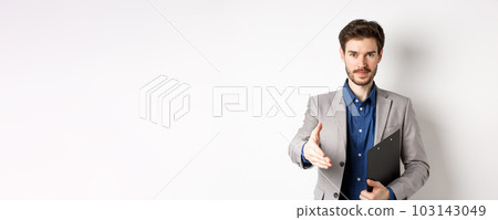 Confident businessman with clipboard giving hand for handshake, greeting business partners on meeting, standing on white background in suit 103143049