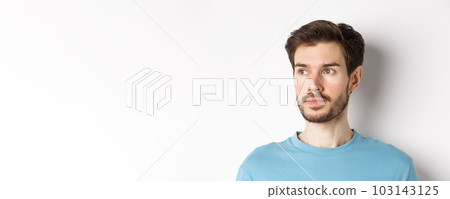 Close-up of handsome male model with beard and moustache, looking left with thoughtful face, standing over white background 103143125