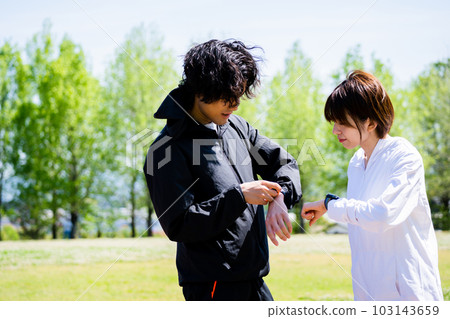 Couple talking while looking at smartwatch Couple talking while looking at smartwatch 103143659